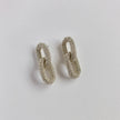 Pair of silver chainmail earrings on a light gray background