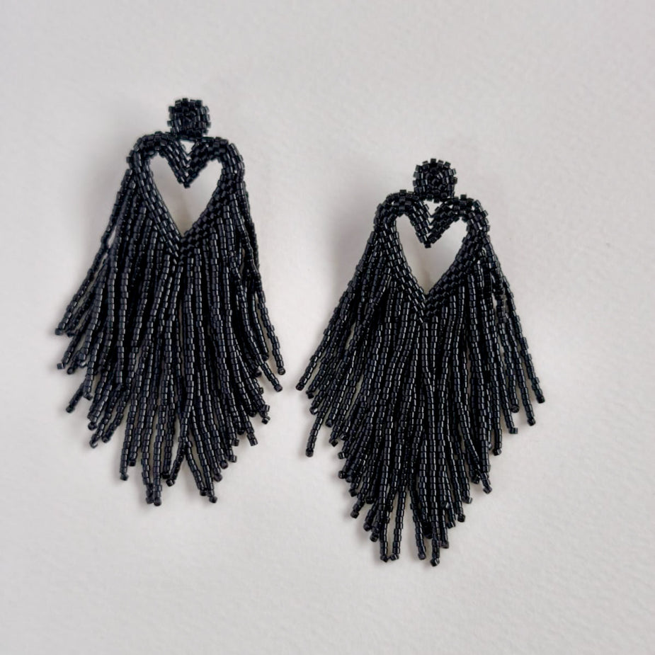 Black beaded fringe earrings on a light gray background