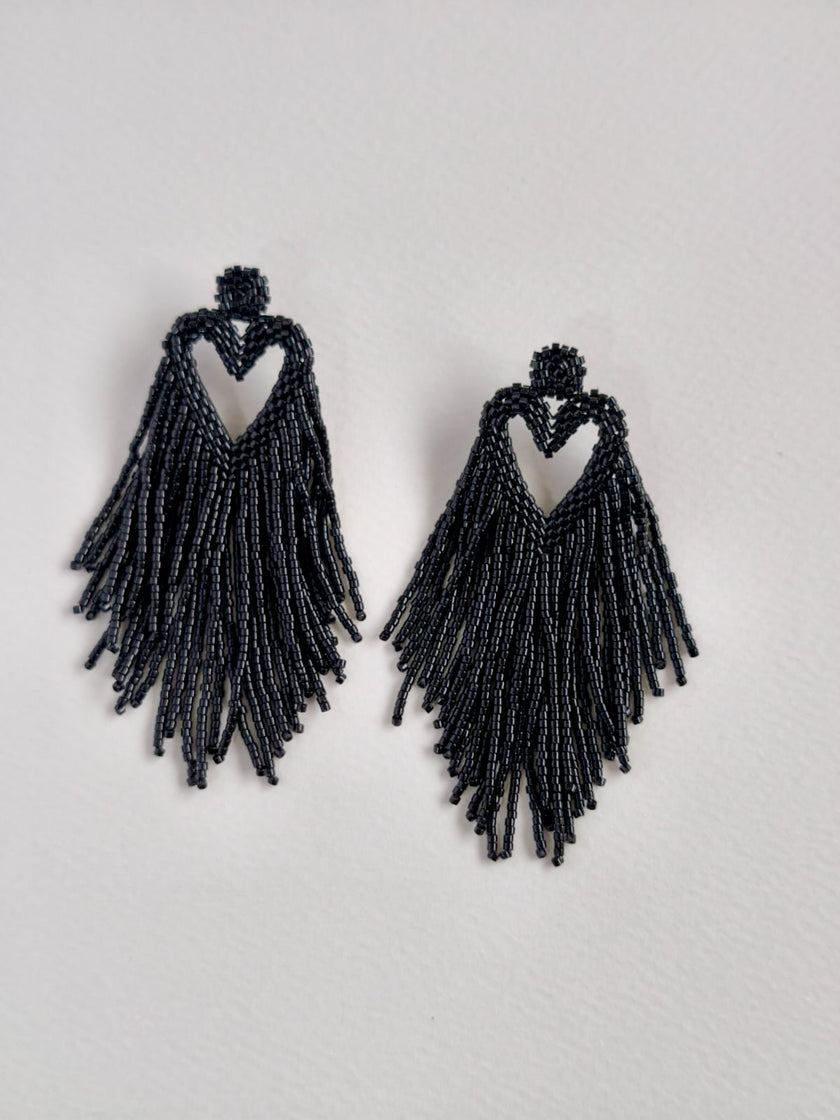 Black beaded fringe earrings on a light gray background
