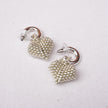 Pair of silver beaded earrings on a light gray background