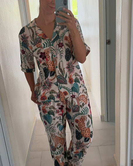 Person wearing a colorful floral pajama set taking a mirror selfie.